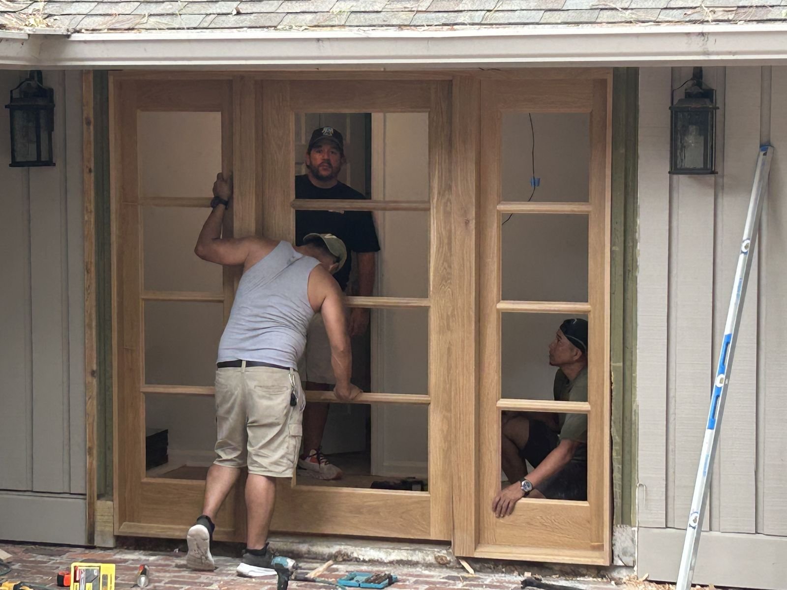 Crew installing custom wood doors with sidelights by Burson Construction, Bluffton SC