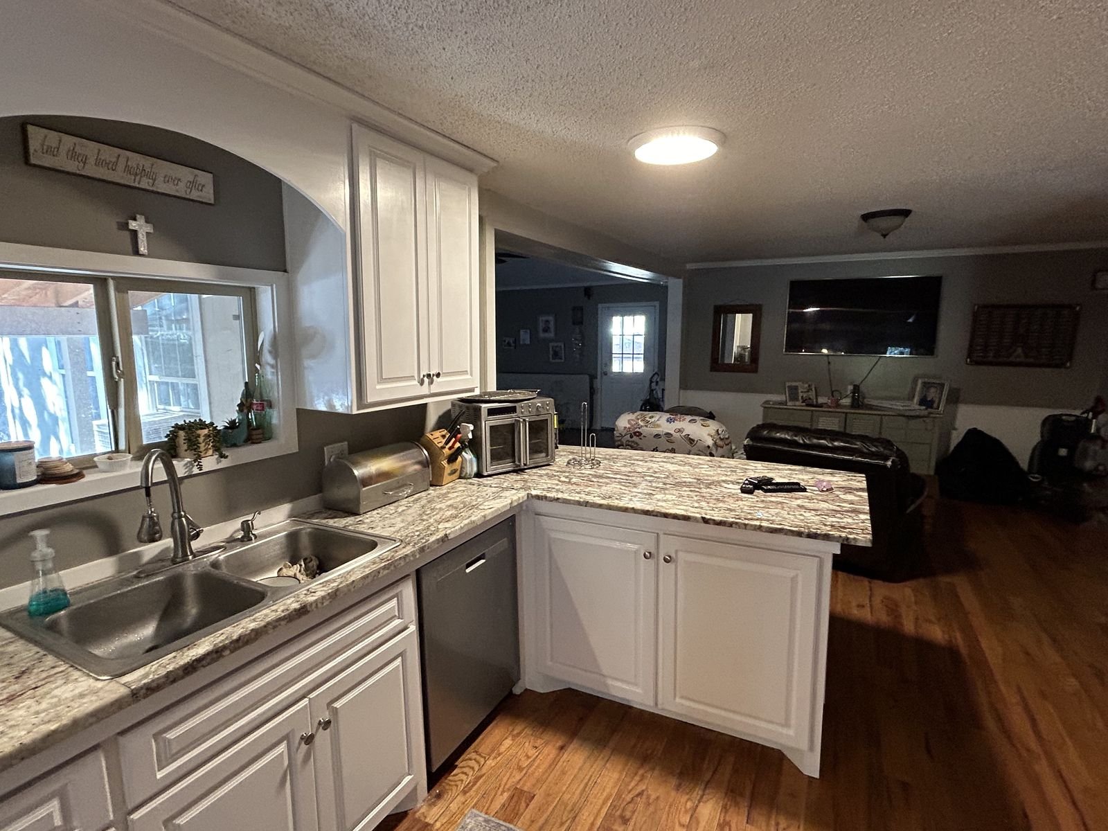 Kitchen sink run and granite peninsula with white cabinets by Burson Construction, Bluffton SC