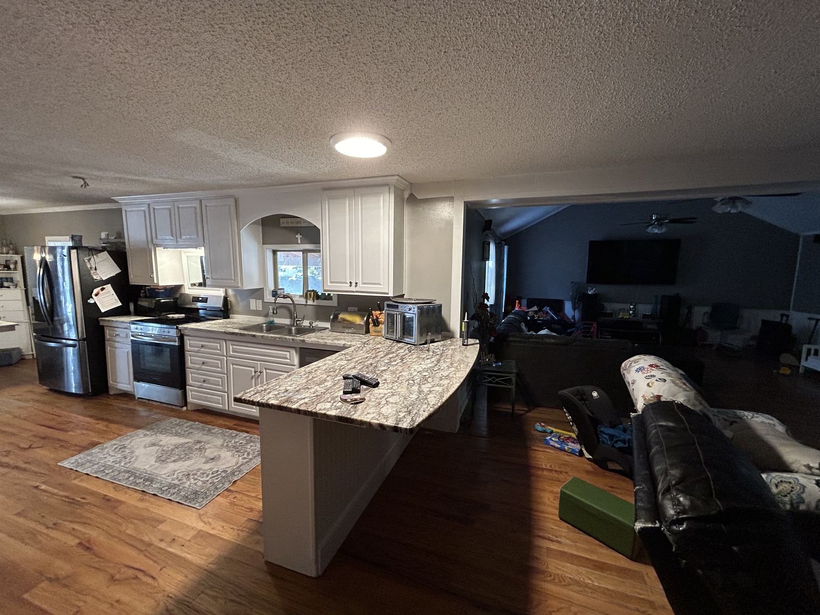 Open-plan kitchen with granite bar and white cabinets by Burson Construction, Bluffton SC