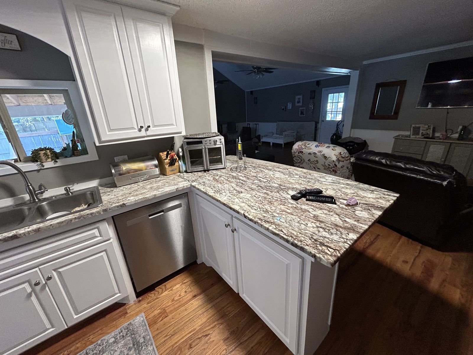 Granite kitchen peninsula opening to the living room by Burson Construction, Bluffton SC